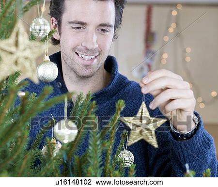 A man decorating the Christmas tree View Large Photo Image Stock Image - A man decorating the Christmas tree. Fotosearch