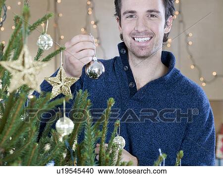 A man decorating the Christmas tree View Large Photo Image Stock Image - A man decorating the Christmas tree. Fotosearch