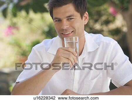 A man drinking a glass of water View Large Photo Image Stock Image - A man drinking a glass of water. Fotosearch