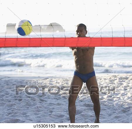 Stock Image - A man playing beach volleyball. Fotosearch