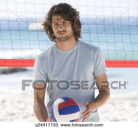 Stock Image - A man playing beach volleyball. Fotosearch