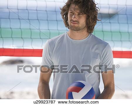 Stock Photo - A man playing beach volleyball. Fotosearch