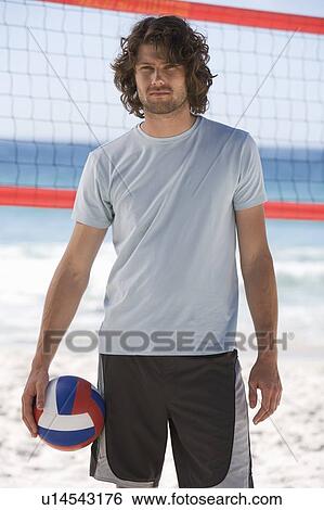 Stock Photograph - A man playing beach volleyball. Fotosearch