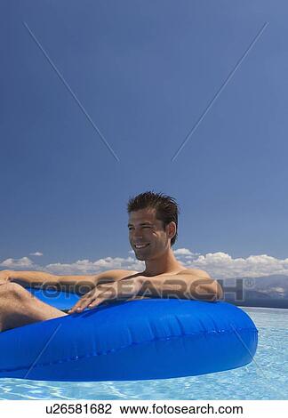 Stock Image - A man relaxing in a pool. Fotosearch