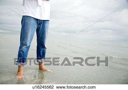 A man standing on a beach View Large Photo Image Stock Image - A man standing on a beach. Fotosearch