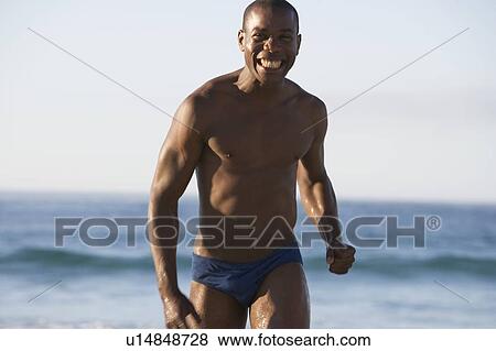 Stock Photo - A man wading in the sea. Fotosearch