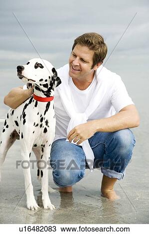A man with his dog on a beach View Large Photo Image Stock Image - A man with his dog on a beach. Fotosearch