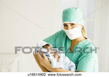 A medical practitioner holding a newborn baby View Large Photo Image Stock Image - A medical practitioner holding a newborn baby. Fotosearch