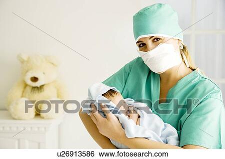 A medical practitioner holding a newborn baby View Large Photo Image Stock Photograph - A medical practitioner holding a newborn baby. Fotosearch