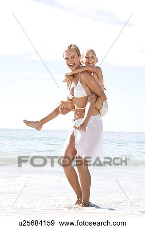 Stock Photo - A mother and daughter playing on the beach. Fotosearch
