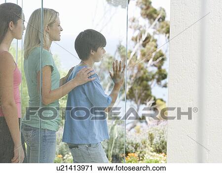 Stock Image - A mother and her children looking at their garden. Fotosearch