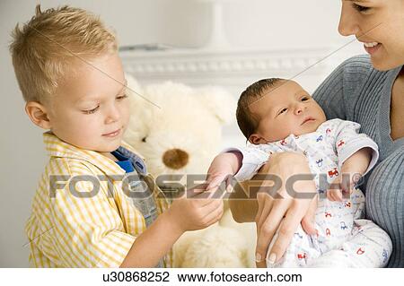 A mother and her son with a new baby View Large Photo Image Stock Image - A mother and her son with a new baby. Fotosearch