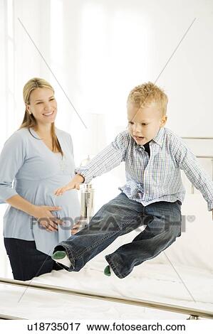A mother and her young son making the bed View Large Photo Image Stock Photo - A mother and her young son making the bed. Fotosearch