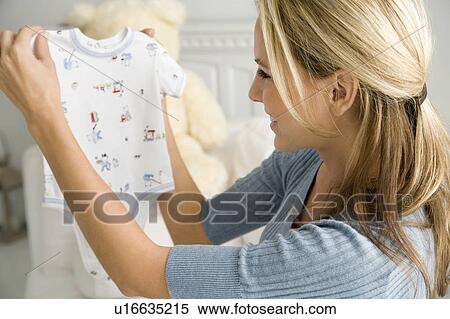 A mother holding a baby's vest View Large Photo Image Stock Photography - A mother holding a baby's vest. Fotosearch