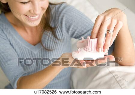 A mother holding a pair of baby bootees View Large Photo Image Stock Photograph - A mother holding a pair of baby bootees. Fotosearch