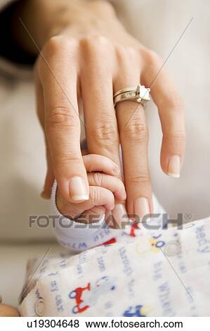 A mother holding her new baby's hand View Large Photo Image Stock Photo - A mother holding her new baby's hand. Fotosearch