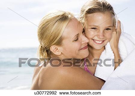 A mother hugging her daughter on the beach View Large Photo Image Stock Image - A mother hugging her daughter on the beach. Fotosearch