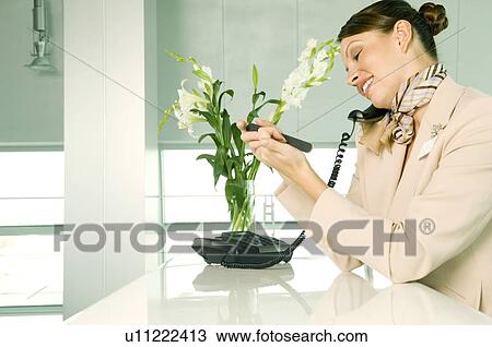 A receptionist talking on the telephone View Large Photo Image Stock Image - A receptionist talking on the telephone. Fotosearch