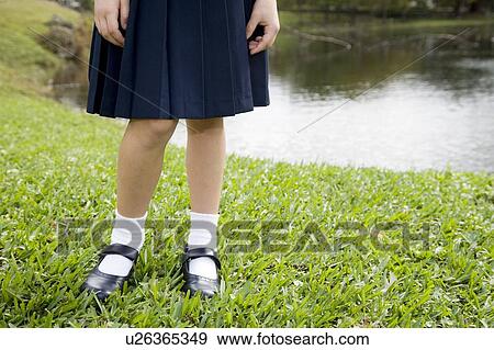 A schoolgirl standing by a pond View Large Photo Image Stock Photo - A schoolgirl standing by a pond. Fotosearch