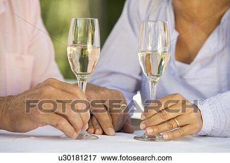 A senior couple celebrating close-up of hands and champagne flutes View Large Photo Image Stock Photo - A senior couple celebrating close-up of hands and champagne flutes. Fotosearch