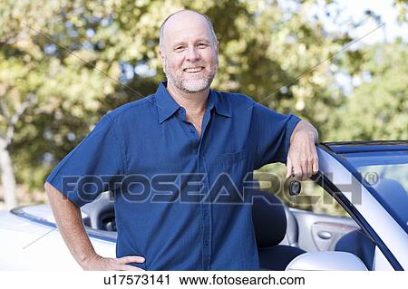 A senior man standing by his car View Large Photo Image Stock Image - A senior man standing by his car. Fotosearch