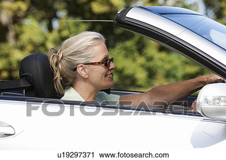 A senior woman driving a car View Large Photo Image Stock Image - A senior woman driving a car. Fotosearch