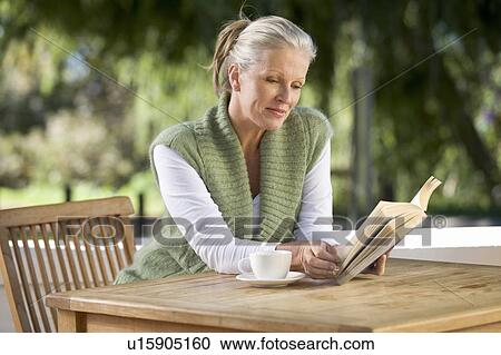 Stock Image - A senior woman reading a book. Fotosearch