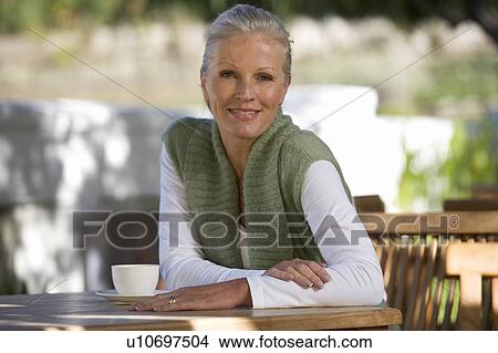 Picture - A senior woman sitting in a garden. Fotosearch