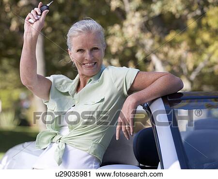 A senior woman standing by her car View Large Photo Image Stock Image - A senior woman standing by her car. Fotosearch