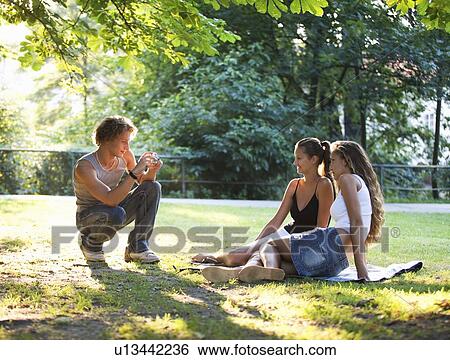 A teenage boy taking a photo of his friends View Large Photo Image Stock Photograph - A teenage boy taking a photo of his friends. Fotosearch