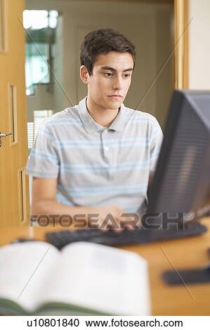 Stock Image - A teenage boy using a computer. Fotosearch