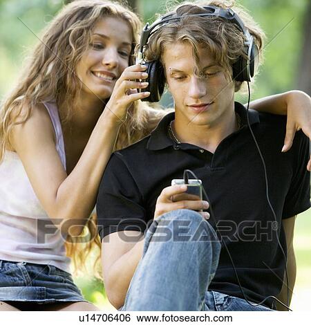 Stock Photograph - A teenage couple listening to music. Fotosearch