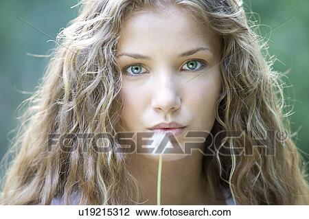 A teenage girl blowing on a dandelion seedhead View Large Photo Image Stock Image - A teenage girl blowing on a dandelion seedhead. Fotosearch