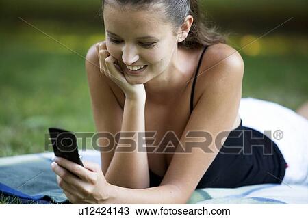 A teenage girl laying in a park View Large Photo Image Stock Image - A teenage girl laying in a park. Fotosearch