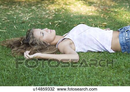 Stock Image - A teenage girl laying in a park. Fotosearch