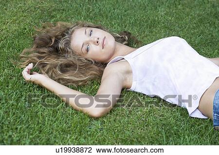 A teenage girl laying in a park View Large Photo Image Stock Image - A teenage girl laying in a park. Fotosearch