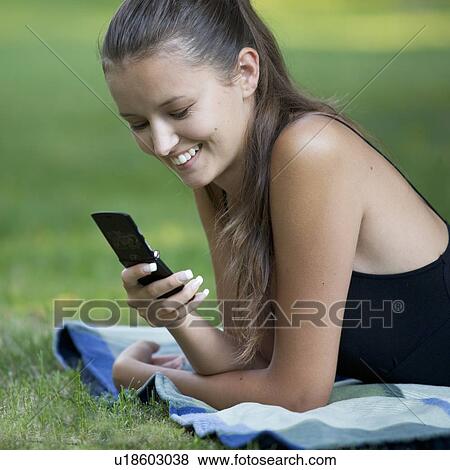 Stock Photo - A teenage girl laying in a park. Fotosearch