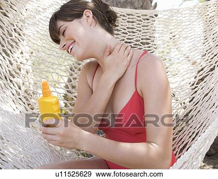 A woman applying sun lotion View Large Photo Image Stock Photo - A woman applying sun lotion. Fotosearch