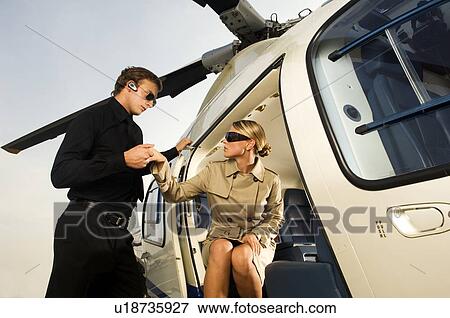 A woman being helped from a helicopter View Large Photo Image Stock Photo - A woman being helped from a helicopter. Fotosearch
