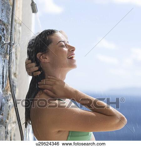 A woman cooling off under a shower View Large Photo Image Stock Photograph - A woman cooling off under a shower. Fotosearch