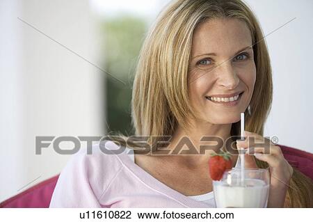 Stock Image - A woman drinking a health drink. Fotosearch