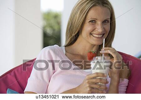 Stock Image - A woman drinking a health drink. Fotosearch