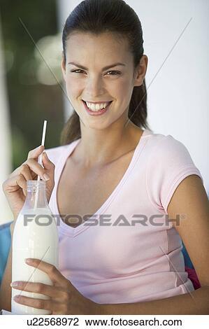 A woman drinking milk through a straw View Large Photo Image Stock Image - A woman drinking milk through a straw. Fotosearch