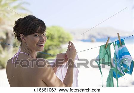 A woman hanging washing out to dry View Large Photo Image Stock Photo - A woman hanging washing out to dry. Fotosearch