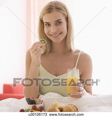 A woman having breakfast in bed View Large Photo Image Stock Image - A woman having breakfast in bed. Fotosearch