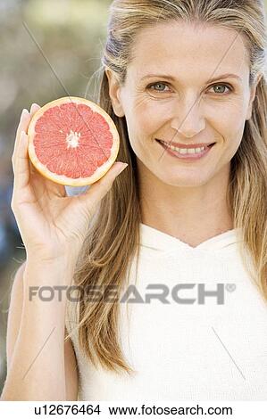 A woman holding a grapefruit View Large Photo Image Picture - A woman holding a grapefruit. Fotosearch