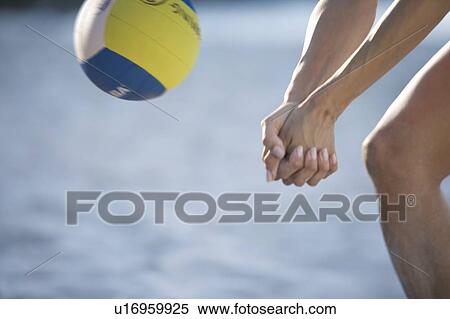 Stock Photography - A woman playing beach volleyball. Fotosearch