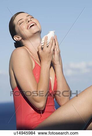 Picture - A woman pouring water from a shell. Fotosearch