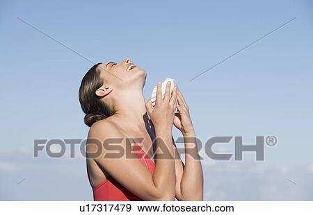 Stock Photo - A woman pouring water from a shell. Fotosearch