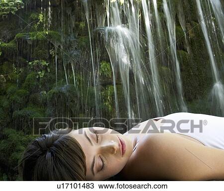 A woman relaxing by a waterfall View Large Photo Image Stock Image - A woman relaxing by a waterfall. Fotosearch